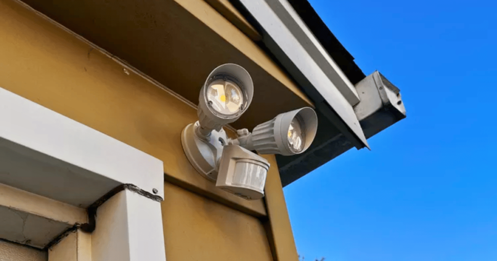 Close-up of outdoor motion sensor lights installed at the corner of a garage
