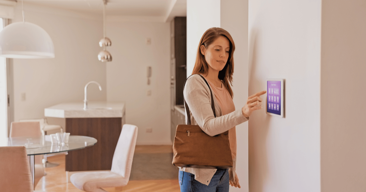 Woman activating her more advanced home security system features through a digital display.